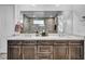 Beautiful bathroom featuring double vanity with dark cabinets, a large mirror, and textured wall at 11954 Camden Ridge Ct, Las Vegas, NV 89138