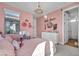 Cozy bedroom features pink walls, decorative chandelier, and a dresser, creating a warm, inviting space at 11954 Camden Ridge Ct, Las Vegas, NV 89138