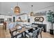 A dining room with pendant lighting, seating for six, light wood floors, and white kitchen in the background at 11954 Camden Ridge Ct, Las Vegas, NV 89138