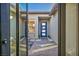 View from entryway showing a modern courtyard with brick flooring, stylish seating, and a blue front door at 11954 Camden Ridge Ct, Las Vegas, NV 89138
