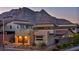 Modern home exterior featuring a well-maintained yard, a stone accent wall, and a mountain backdrop at 11954 Camden Ridge Ct, Las Vegas, NV 89138