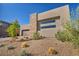 Modern home exterior with stone accents, desert landscaping, and a two-car garage at 11954 Camden Ridge Ct, Las Vegas, NV 89138