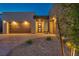 Modern single-story home featuring sleek architectural design, warm lighting, and landscaped front yard at 11954 Camden Ridge Ct, Las Vegas, NV 89138