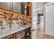 Laundry room boasts dark wood cabinets, eye-catching floral tile backsplash, and a utility sink at 11954 Camden Ridge Ct, Las Vegas, NV 89138