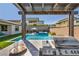 Built-in outdoor BBQ bar featuring a grill and sink with views of the backyard, pool and spa at 11954 Camden Ridge Ct, Las Vegas, NV 89138
