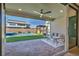 Covered patio with stylish seating area, ceiling fan and view of the backyard pool and outdoor kitchen at 11954 Camden Ridge Ct, Las Vegas, NV 89138