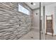 Modern shower with stone accent wall, a built-in seat, and a glass door at 11954 Camden Ridge Ct, Las Vegas, NV 89138