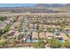 Expansive aerial view showcases a neighborhood with pools and solar panels, set against a mountain backdrop at 1212 Anime Dr, Las Vegas, NV 89144