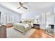 Relaxing main bedroom featuring hardwood floors, shutters, a ceiling fan, and a neutral color palette at 1212 Anime Dr, Las Vegas, NV 89144