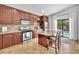 Updated kitchen featuring an island with seating and stainless steel appliances with views of the pool and outdoor areas at 1212 Anime Dr, Las Vegas, NV 89144