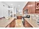 Open-concept kitchen with a large island, stainless steel appliances, and tile backsplash at 1212 Anime Dr, Las Vegas, NV 89144