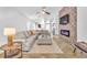 Cozy living room with a stone fireplace, comfortable seating, a ceiling fan, and modern decor at 1212 Anime Dr, Las Vegas, NV 89144