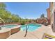 Backyard oasis with a sparkling pool, relaxing hot tub, and comfortable seating area at 1212 Anime Dr, Las Vegas, NV 89144