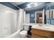 Bathroom with a shower-tub combo and a wood vanity with white sink and blue accent walls at 1301 Nugget Creek Dr, Las Vegas, NV 89108