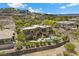 Elevated view of a modern home boasting a pool, spa, and lush landscaping in a hillside setting at 1472 Macdonald Ranch Dr, Henderson, NV 89012