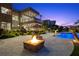A modern backyard features a stone fire pit, desert landscaping, and a swimming pool at 1472 Macdonald Ranch Dr, Henderson, NV 89012