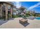 Modern backyard with stone accents, fire pit, pool and lush landscaping, perfect for outdoor living and entertainment at 1472 Macdonald Ranch Dr, Henderson, NV 89012