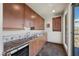 Bar area with wooden cabinets, marble countertops, mini fridge, and tile floors at 1472 Macdonald Ranch Dr, Henderson, NV 89012