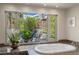 Luxurious bathroom featuring a soaking tub, scenic window view, and marble accents at 1472 Macdonald Ranch Dr, Henderson, NV 89012