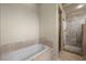 Elegant bathroom featuring a soaking tub, and glass-enclosed shower at 1472 Macdonald Ranch Dr, Henderson, NV 89012