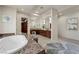 Large bathroom featuring a soaking tub, double vanity with lots of cabinet space, and decorative blue rug at 1472 Macdonald Ranch Dr, Henderson, NV 89012