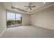 Carpeted bedroom with a ceiling fan, and sliding glass doors to a private balcony with scenic views at 1472 Macdonald Ranch Dr, Henderson, NV 89012
