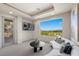 Bright bonus room featuring a large window with mountain views and a comfy curved sofa at 1472 Macdonald Ranch Dr, Henderson, NV 89012
