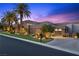 Modern home with meticulous landscaping, stone accents, a dark driveway, and a porte-cochere at 1472 Macdonald Ranch Dr, Henderson, NV 89012