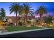 Contemporary home featuring stone accents, professional landscaping, and mature palm trees at 1472 Macdonald Ranch Dr, Henderson, NV 89012