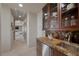 Butlers pantry with granite countertops and rich wood cabinetry at 1472 Macdonald Ranch Dr, Henderson, NV 89012