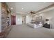 Luxury main bedroom featuring a stone fireplace, tray ceiling, and neutral carpet at 1472 Macdonald Ranch Dr, Henderson, NV 89012