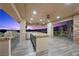 A modern outdoor kitchen has stainless steel appliances, sink, and beautiful stone countertops on a spacious patio at 1472 Macdonald Ranch Dr, Henderson, NV 89012