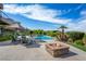 Inviting pool area with lounge seating, fire pit, and meticulously manicured landscaping for ultimate relaxation at 1472 Macdonald Ranch Dr, Henderson, NV 89012
