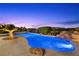 A long, narrow pool surrounded by mature landscaping features a rock waterfall at 1472 Macdonald Ranch Dr, Henderson, NV 89012