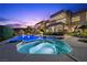 Luxury home's backyard showcasing a pool, hot tub, waterfall feature, and lounge area at dusk at 1472 Macdonald Ranch Dr, Henderson, NV 89012