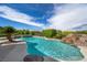 Relaxing pool area with lush landscaping, rock features, and serene atmosphere for luxurious outdoor enjoyment at 1472 Macdonald Ranch Dr, Henderson, NV 89012