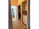 Hallway featuring neutral tile flooring, a view to the bathroom and white cabinets at 1851 Hillpointe Rd # 2621, Henderson, NV 89074