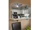 View of the open kitchen featuring white cabinets, a breakfast bar and stainless appliances at 1851 Hillpointe Rd # 2621, Henderson, NV 89074