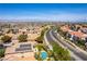 Wide aerial shot capturing a neighborhood with desert landscaping, tile roofs, and a cityscape backdrop at 2434 Amoretti St, Henderson, NV 89052