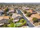 Scenic aerial view of a residential area, displaying houses with solar panels, mature trees, and a sparkling pool at 2434 Amoretti St, Henderson, NV 89052