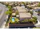 High-angle aerial view presenting homes with manicured lawns, a pool, and a neatly planned community layout at 2434 Amoretti St, Henderson, NV 89052