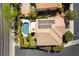 Aerial view of a backyard featuring a blue swimming pool, solar panels, a tiled roof, and manicured landscaping at 2434 Amoretti St, Henderson, NV 89052