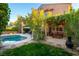 Lush backyard featuring a sparkling pool, mature landscaping, and a charming pergola-covered seating area at 2434 Amoretti St, Henderson, NV 89052