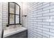Modern powder room featuring sleek subway tile walls, vanity, and decorative mirror at 2434 Amoretti St, Henderson, NV 89052