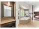 Bright bathroom features a large tub, with a dressing area and mirror at 2434 Amoretti St, Henderson, NV 89052