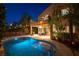 A nighttime view of the backyard featuring a refreshing pool and inviting patio, perfect for relaxing and entertaining at 2434 Amoretti St, Henderson, NV 89052