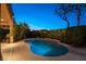 Backyard oasis featuring a tranquil pool with a water feature, enhanced by charming string lights and mature landscaping at 2434 Amoretti St, Henderson, NV 89052