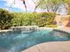 A lush outdoor space with a water feature flowing into the swimming pool at 2434 Amoretti St, Henderson, NV 89052