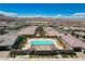 Wide aerial shot of a community pool and neighborhood nestled against a backdrop of mountains under a blue sky at 2579 Speyburn Ave, Henderson, NV 89044