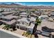 An aerial view of a residential neighborhood showcasing modern homes with solar panels against a mountain backdrop at 2579 Speyburn Ave, Henderson, NV 89044